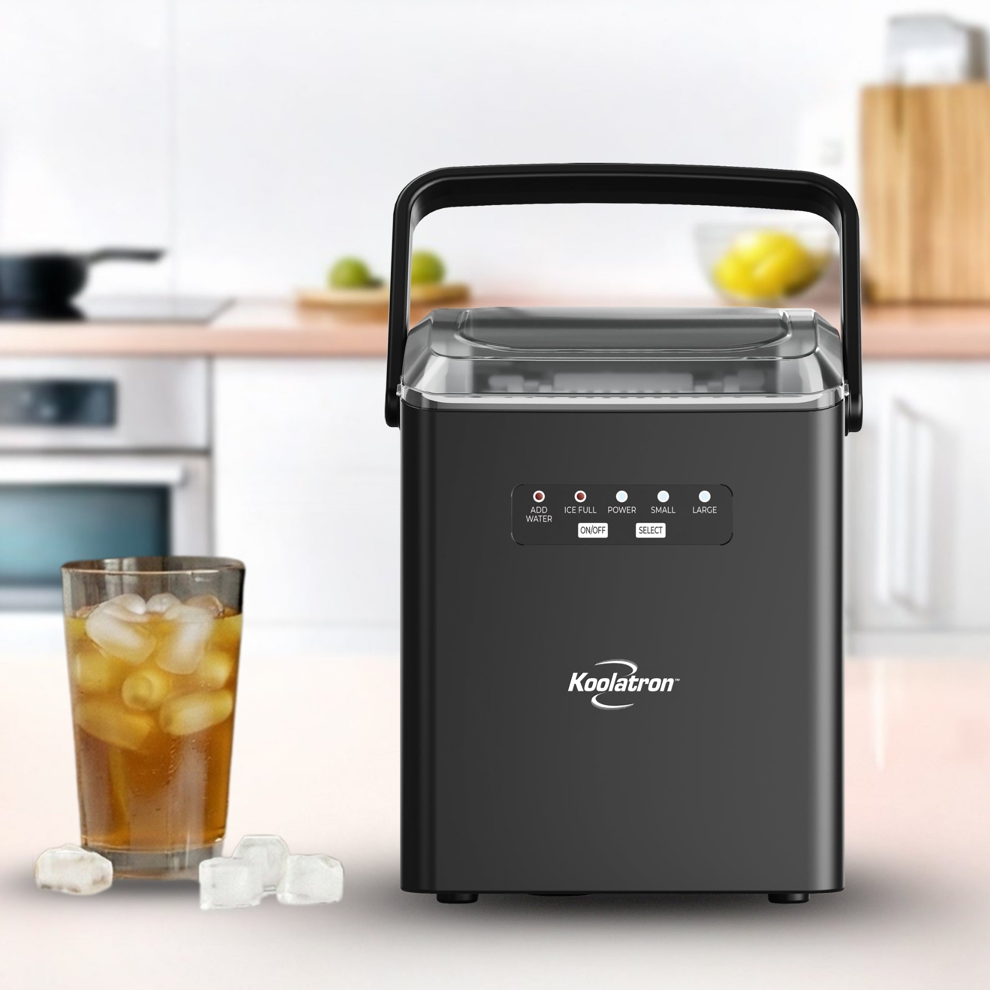 Automatic ice maker on a white countertop in a bright kitchen with an iced drink beside it
