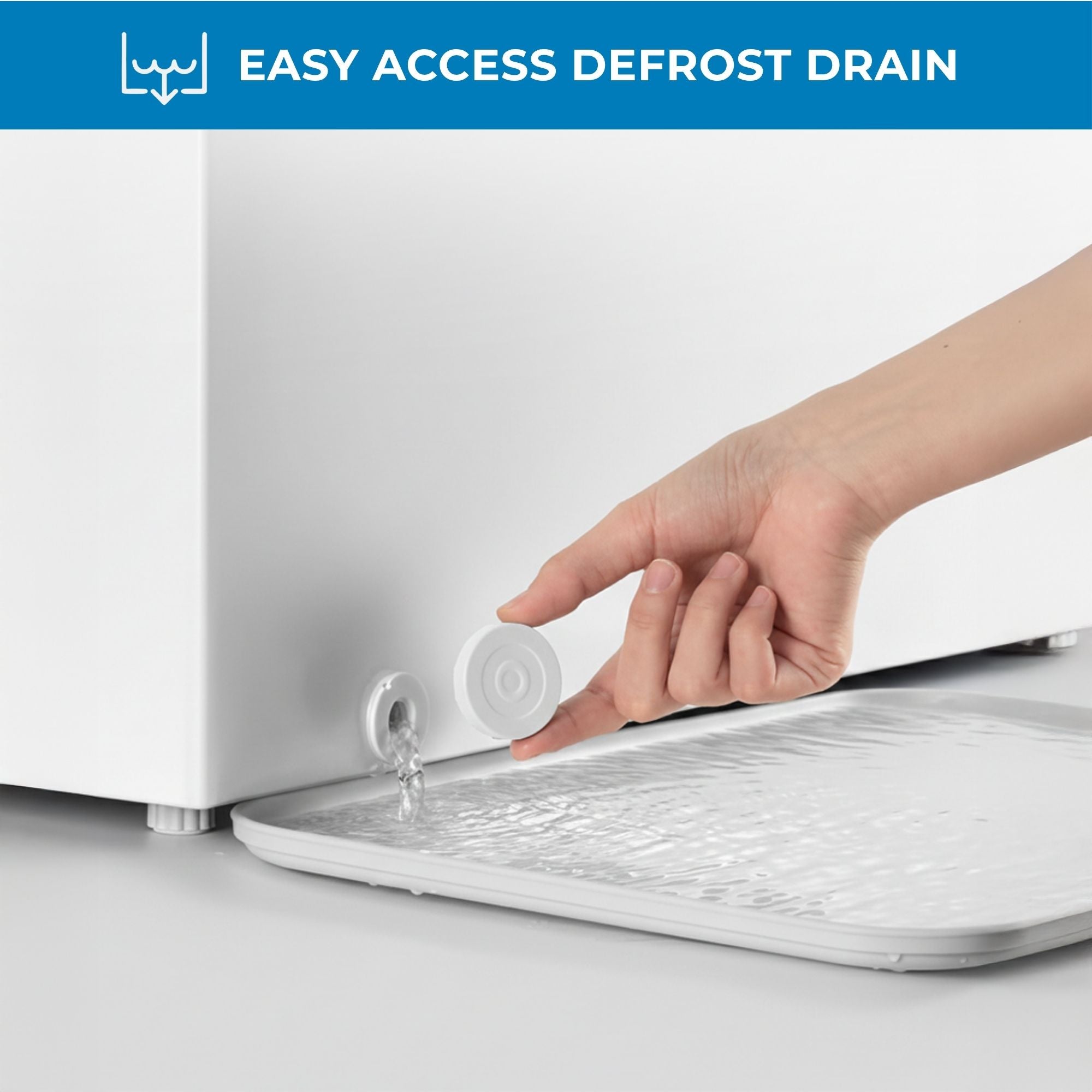 Closeup of a hand holding the drain cover and water flowing from the front-access defrost drain with text above reading, "Easy access defrost drain"