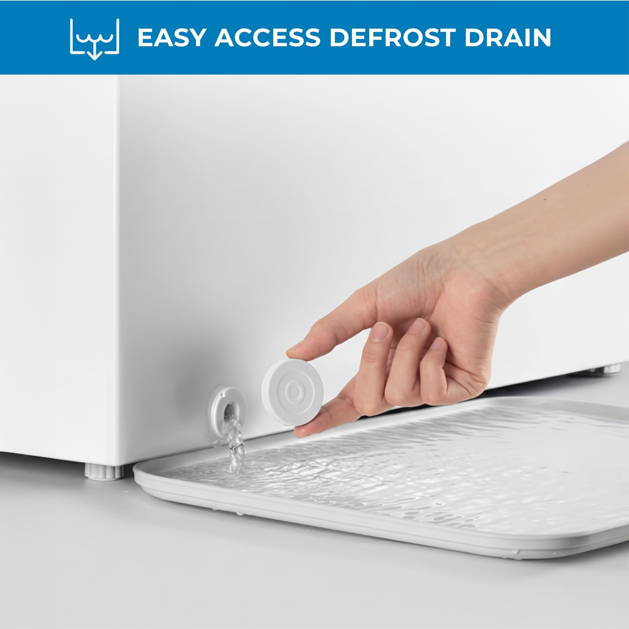 Closeup of a hand holding the drain cover and water flowing from the front-access defrost drain with text above reading, "Easy access defrost drain"