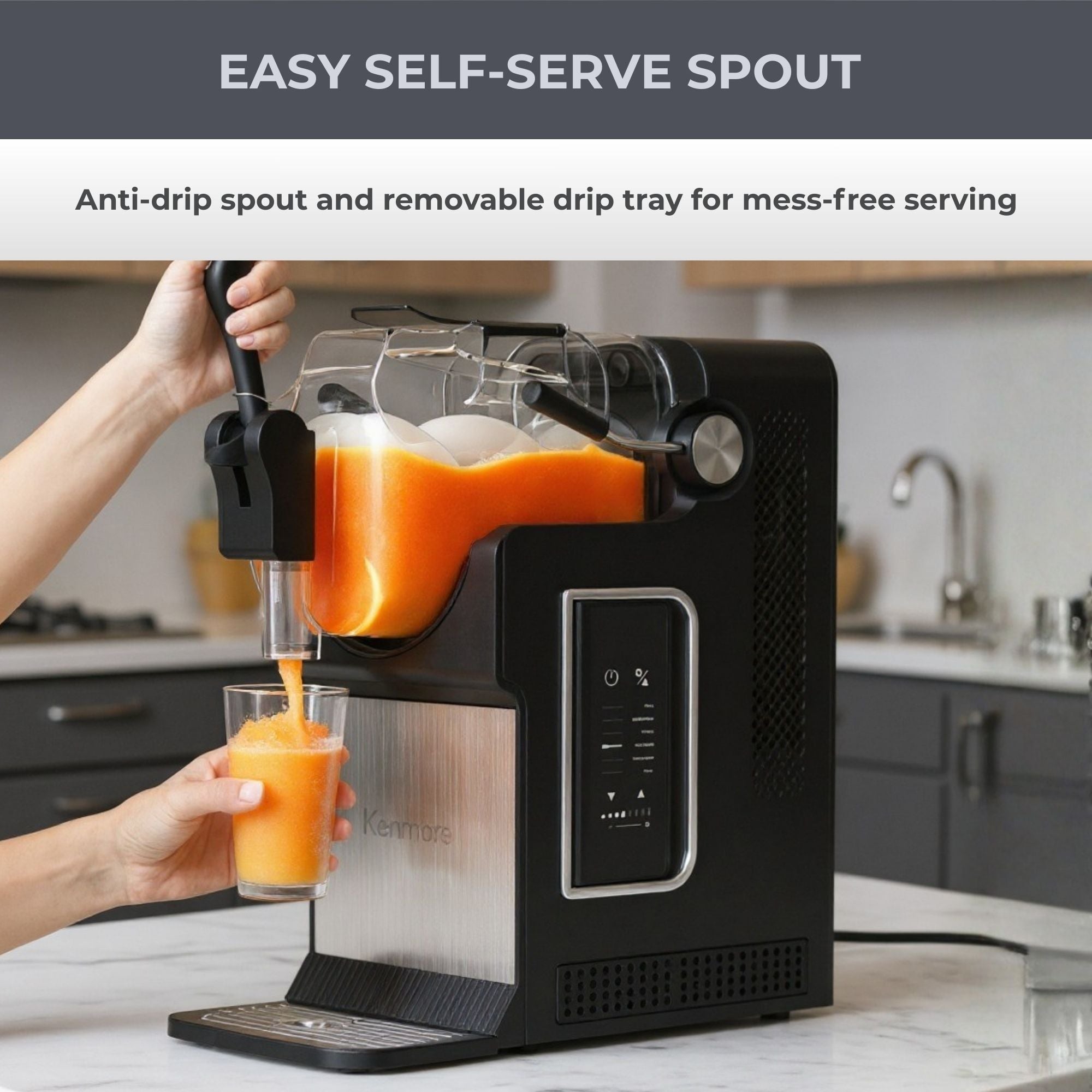 Kenmore slushie and frozen drink machine on a white marble countertop with grey kitchen cupboards in the background. A person’s hands are visible pulling down on the level to dispense orange slush into a glass. Text above reads, “Easy self-serve spout: Anti-drip spout and removable drip tray for mess-free serving.”